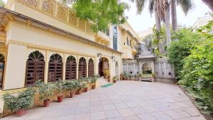 乌代浦摩哂陀普拉喀什酒店的一座种植盆栽植物的建筑的庭院