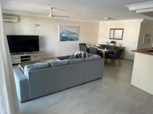 黄金海岸Crown Towers Resort Apartments的客厅配有灰色的沙发和电视