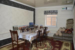 希瓦Khiva Mirza Bobur Guest House的一间带桌椅和窗户的用餐室