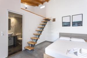 阿特米达Spitakia-Cozy & Comfy Apartments 10minutes from the airport的一间卧室设有一张床和一个螺旋楼梯