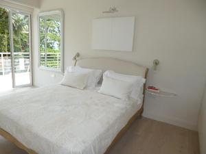 博瓦隆米米别墅的一间卧室配有一张带白色床单的床和一扇窗户。