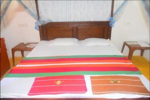 坦加拉Jayanika Residence的床上有条纹的彩色毯子