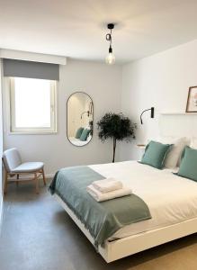 布尔戈斯HomeSanGil的一间卧室配有一张带镜子和椅子的床
