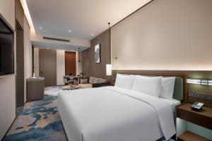 定州定州香江万达锦华酒店的一间带白色大床的卧室和一间客厅