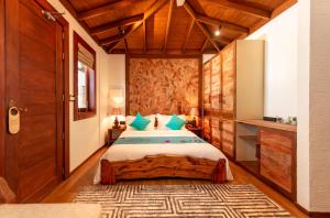 福拉杜岛Island Luxury Boutique Hotel - Fulhadhoo的一间卧室配有一张大床和木制床头板