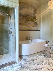 希佛萨姆多朋伯格别墅酒店的设有带浴缸和淋浴的浴室。
