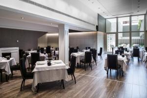 巴塞罗那加泰罗尼亚格拉西亚大道酒店的餐厅配有桌椅和白色的桌布
