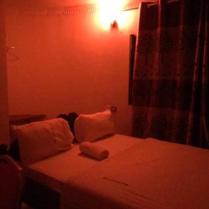 Sanya JuuMacarela Inn的一间卧室配有带白色床单和枕头的床。