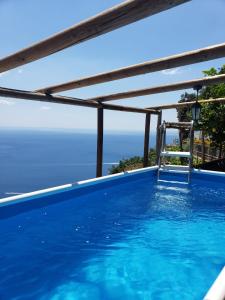 弗洛里Fico D'India Relais的一个带椅子的游泳池,俯瞰着大海
