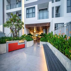 Ấp Phú ThọHoa's lovely 2-bedroom condo with pool的一座白色的大建筑,庭院里种有植物