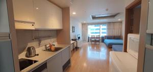 首尔JSM Studio Hongdae的一间厨房和一个客厅,客厅配有沙发