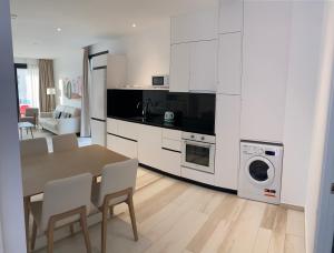 阿尔考斯布里AZAHAR BEACH Red Apartments & Spa的厨房配有桌椅和洗衣机。