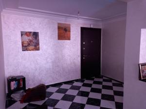 卡萨布兰卡APPARTEMENT ZENITH的一间设有 ⁇ 板地板和黑色门的房间
