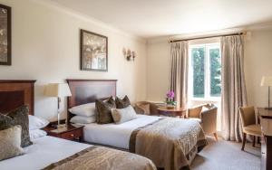 贝辛斯托克Audleys Wood Hotel, Basingstoke的酒店客房设有两张床和窗户。
