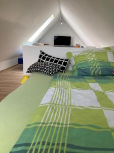 里格斯堡Herzhof Lampert的卧室配有带枕头的绿色和白色床。