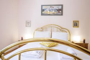 佩塔里德海昂Gold n Blu Petalidi的一间卧室配有一张金色床架的床
