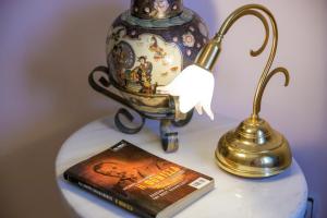 佩塔里德海昂Gold n Blu Petalidi的一张带花瓶、书和灯的桌子