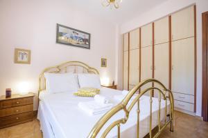 佩塔里德海昂Gold n Blu Petalidi的卧室配有白色的床和木制橱柜。