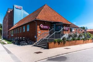 哥本哈根哥本哈根GO酒店的一座砖砌建筑,外面有自行车停放