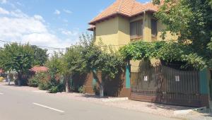 多亚马伊Villa Mugur的街道边有围栏的黄色房子
