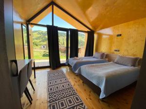 DzhergalanPeak Lodge Jyrgalan的带大窗户的客房内的两张床
