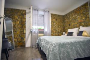 锡尼Luxury apartments Petrovac的一间卧室设有一张床和石墙