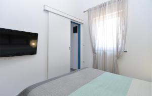 佩罗杰House Peroj 2195的一间卧室配有一张床和一台平面电视