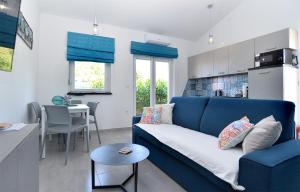 佩罗杰House Peroj 2195的一间带蓝色沙发的客厅和一间厨房