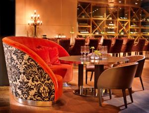美因茨美因茨瑞格奈斯酒店的餐厅设有2张桌子和椅子以及葡萄酒架