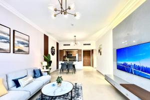 迪拜GOODWOOD SUITES HOMES VACATION的客厅配有白色沙发和大电视