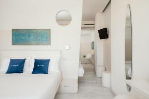 雷卡纳蒂港Life Hotel Seaview & Spa的白色客房 - 带蓝色枕头的床