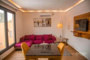 努瓦克肖特Marrakech - Premium Suite的客厅配有紫色沙发和桌子