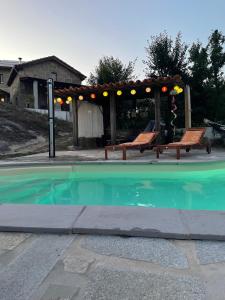 奥利维拉多霍斯比托昆塔科博拉尔度假屋的一个带凉亭和两个长椅的游泳池