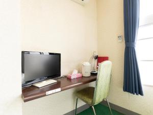 柏崎市Tabist Business Hotel Chitose Kashiwazaki的客房设有一张桌子、一台电视和一把椅子