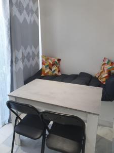 欧奈索斯博伊斯Sublime & neuf Studio près de CDG-Parc d'expo的带沙发的房间里一张桌子和一把椅子