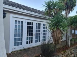 格拉罕镇Cottage on Clarke的一个带白色门和棕榈树的车库