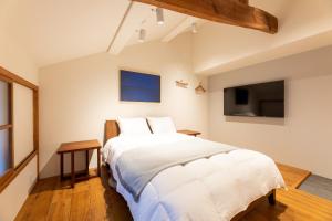 出云市MACHIYA HOTEL madoka - Vacation STAY 65847v的一间带大床和电视的卧室
