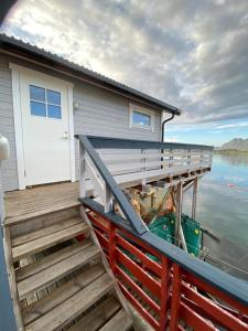 GjesværUtsikten的水面上设有木甲板的房子
