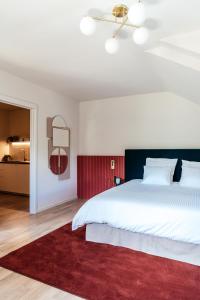 德平特Villa Parkbos的卧室配有一张白色大床和红色地毯。