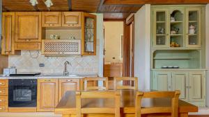 ArroneBorgo San Valentino的厨房配有木制橱柜和桌椅