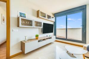 大加那利岛拉斯帕尔马斯Home2Book Charming Urban Siete Palmas的一间带电视和大窗户的客厅