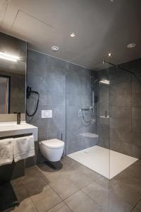 格平根RiKu HOTEL Göppingen的带淋浴、卫生间和盥洗盆的浴室