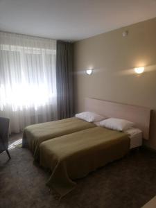 阿利图斯Hotel Senas Namas的酒店客房设有两张床和窗户。
