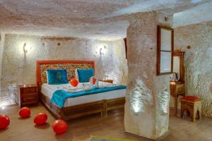于尔居普卡帕多西亚阿巴拉洞穴酒店的卧室配有一张红色气球床,位于地板上
