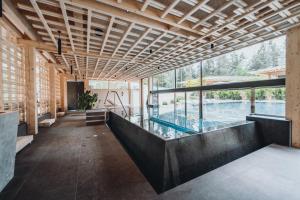 修希Sensoria Dolomites的大型客房中央的游泳池,设有窗户