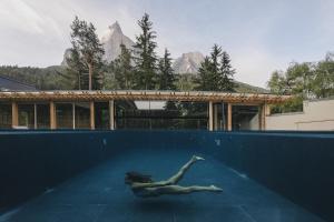 修希Sensoria Dolomites的一位女性在山地游泳池游泳