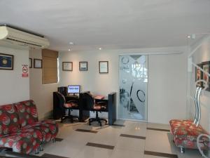 皮乌拉Intiotel Piura的一间设有椅子和一张桌子及电脑的等候室