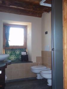 奥斯塔Alloggio Gran Paradiso的浴室设有2个卫生间、水槽和窗户。