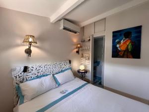 滨海卡涅格里马迪尼斯住宿加早餐旅馆的卧室配有一张床,墙上挂有绘画作品