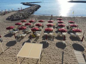 圣温琴佐MIIO HOTEL的海滩上一群红伞和椅子